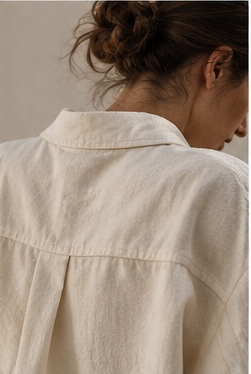 Back view of a woman in an undyed cotton shirt